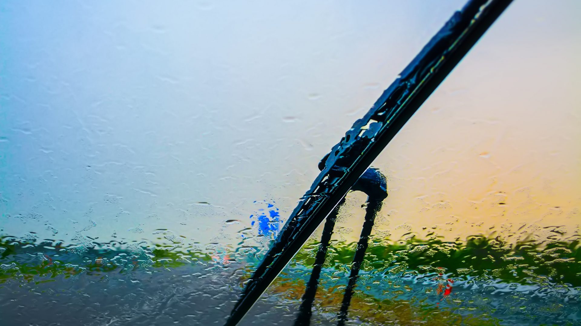 Wiper on a wet windshield at sunset